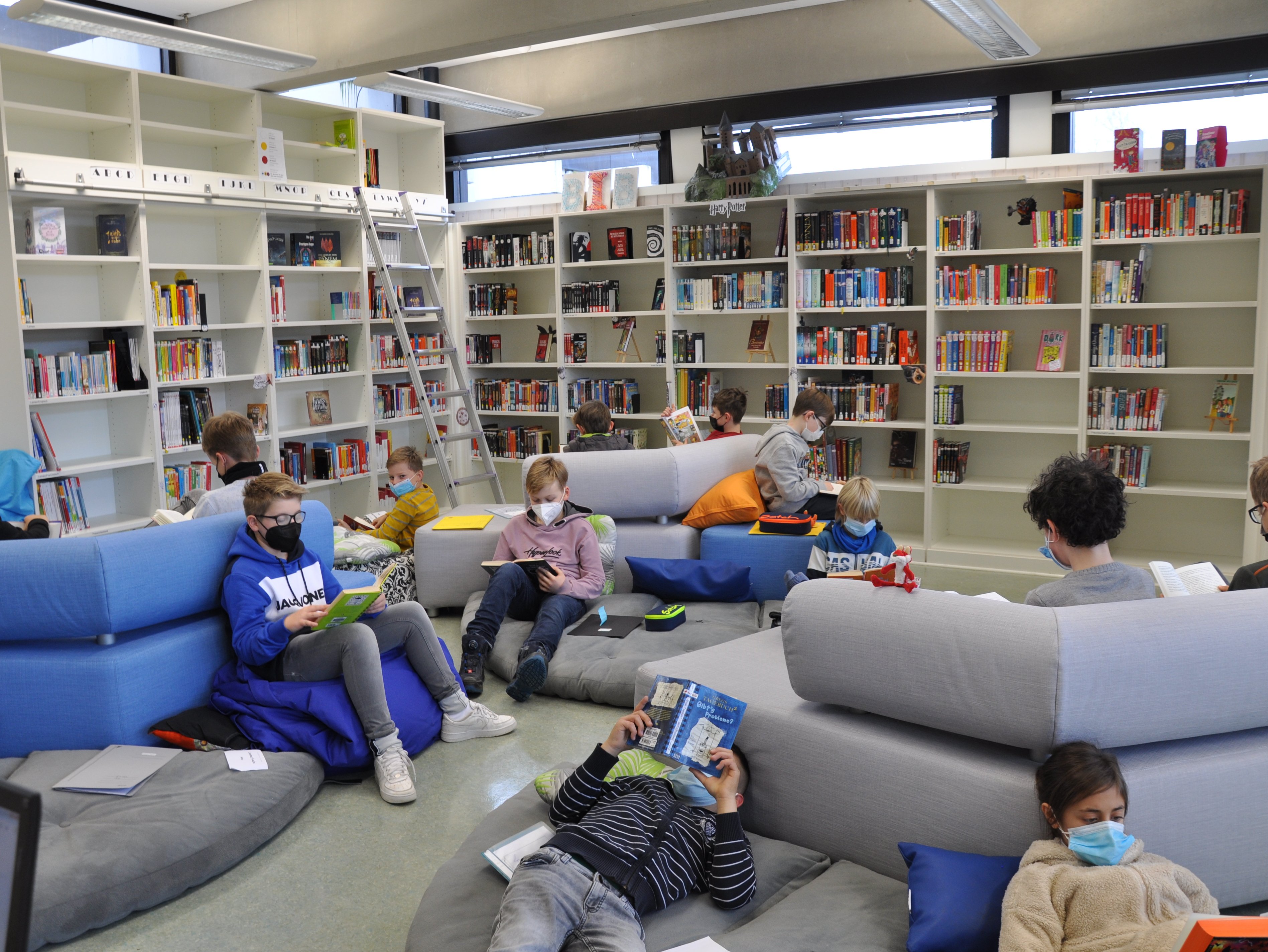 Schülerinnen und Schüler lesen in der Schülerbibliothek